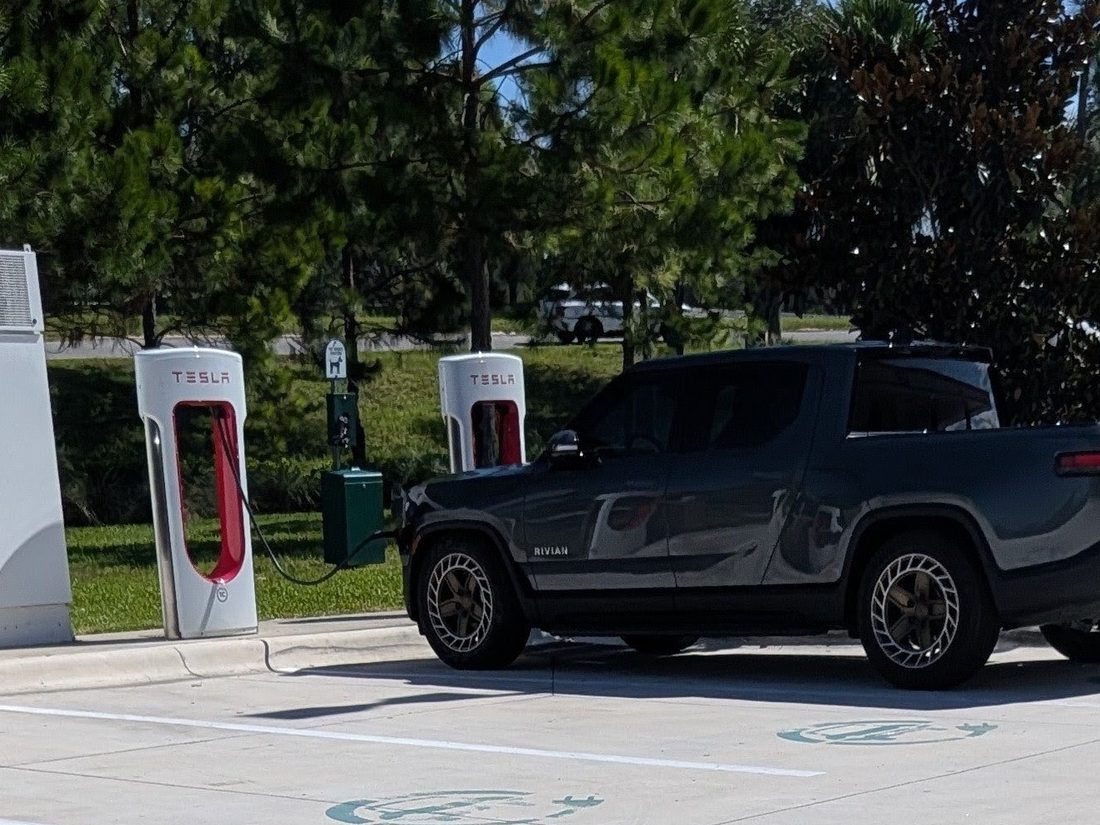 Rivian R1T charging at a Tesla Supercharger